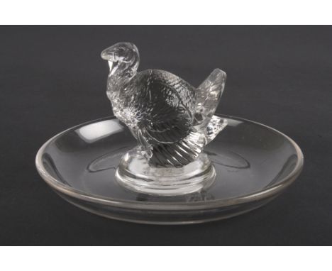An R. Lalique clear glass ring dish
mounted with a model of a turkey. Etched signature to base 'R. Lalique'.Dimensions: 11 cm