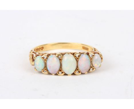 An 18ct gold, opal and diamond five stone ring
the five oval opals interspersed with diamond points, in a scrolled mount, hal