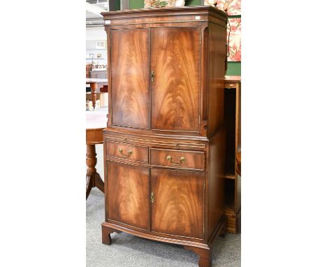 A Reproduction Georgian Style Flame Mahogany Drinks Cabinet, twin cupboard doors with mirrored interior, base with two drawer