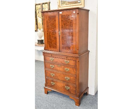 A Reproduction Georgian Style Walnut and Mahogany Crossbanded Drinks Cabinet, twin doors, mirrored interior, base with brushi