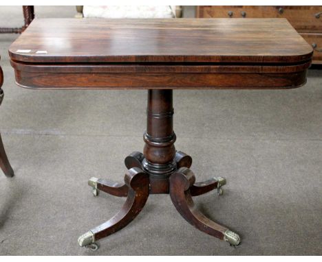 A Regency Rosewood Fold Over Card Table with green baize inset, raised on turned column to four outswept legs on castors, 73c