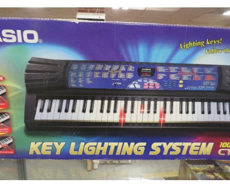 A boxed Casio key lit system organ with pre-loaded songs (unchecked) 