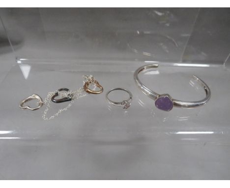 A silver bangle, necklace, and ring