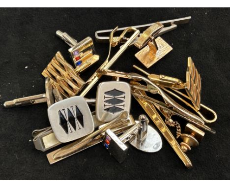 A collection of cuff links and tie pins