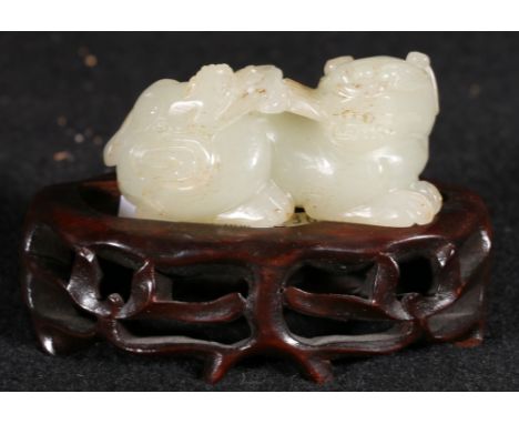 Chinese carved jade model of a recumbent lion dog and puppy, associated carved hardwood stand, 7cm. CONDITION REPORT: Carving
