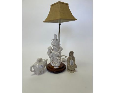 A 20th Century Chinese Dehua kiln white glazed lamp depicting Guanyin lavishly dressed and sitting in the lotus position, set