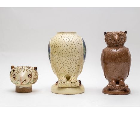 Two earthenware vessels in the form of owls, one in a cream slip heightened in blue, green and brown and having a removable h