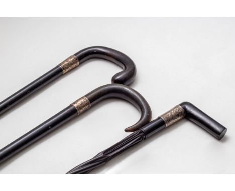 An ebony spiral walking stick with silver mount and two others, both with silver mounts CONDITION REPORT: Condition informati