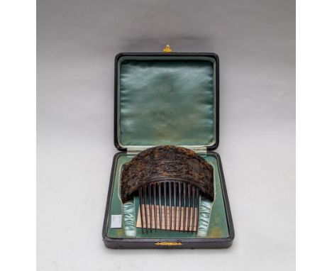 A 19th Century Cantonese tortoiseshell comb, finely carved figures in a garden landscape on face and reverse, 16.5cm wide, ca