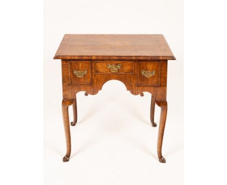 A George II walnut and featherbanded lowboy, the quarter veneered top above three drawers on cabriole legs with pointed pad f