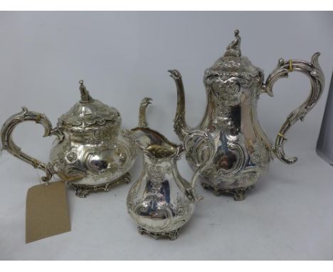 A silver plated teapot and hot water pot, repousse embossed with flowers and C-scrolls, seated figures to finials, mask and b