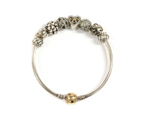 A sterling silver Pandora bangle, with gold clasp, marked 585, Dutch oak leaf mark, suspending eight silver charms, to includ