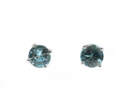 A pair of white gold blue zircon stud earrings, with a circular mixed cut blue zircon, four claw set to post and butterfly fi