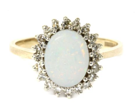 A 9ct gold opal and diamond cluster ring, an oval cabochon opal to surround of eight cut diamonds, all claw set to a wire bas