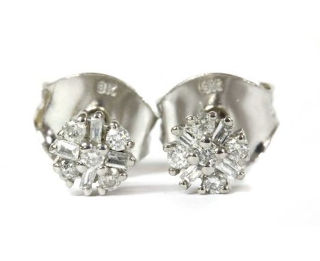 A pair of white gold diamond cluster stud earrings, a brilliant cut diamond to surround of alternating brilliant and baguette