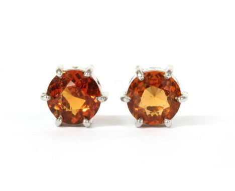 A pair of white gold single stone hessonite garnet earrings, a circular mixed cut hessonite garnet, approximately 6.2mm, claw