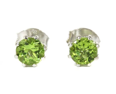 A pair of white gold single stone peridot stud earrings, a circular mixed cut peridot, approximately 5mm, claw set to post an