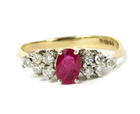 A 9ct gold ruby and diamond eleven stone ring, an oval mixed cut ruby, with two pairs of brilliant cut diamonds at each side,