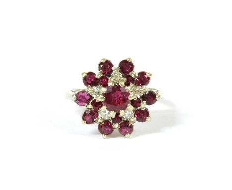 A 9ct white gold ruby and diamond cluster ring, a circular mixed cut ruby claw set to the centre, to two tier surround of cir