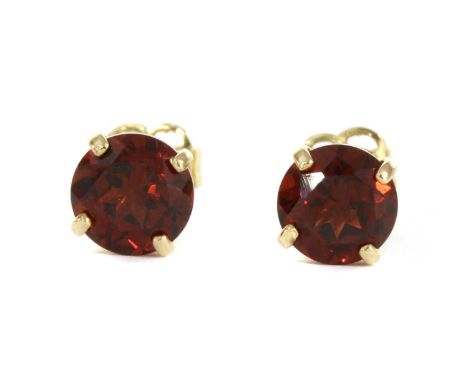 A pair of gold single stone garnet stud earrings, a circular mixed cut garnet, 5mm, claw set to post and butterfly fittings, 