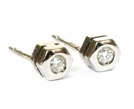 A pair of 18ct white gold single stone diamond stud earrings, a brilliant cut diamond flush set to an hexagonal collect, with