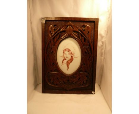 Ceramic plaque decorated with portrait of a Dutch girl in carved wood frame