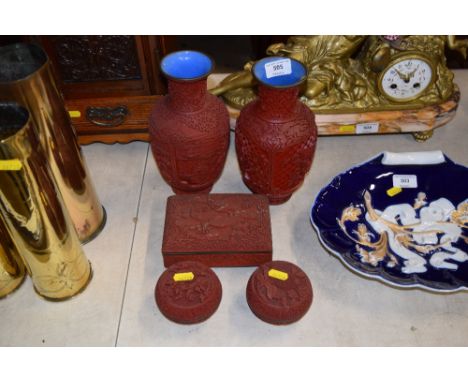A pair of Chinese cinnibar style vases; together with a similar trinket box; and two circular bowls and covers 