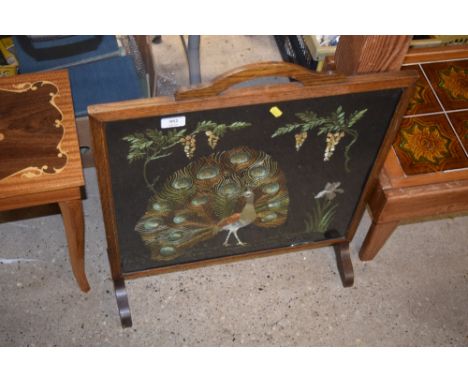 An oak framed and embroidered firescreen