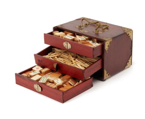 A BONE AND BAMBOO MAHJONG SET
With red lacquered wooden case, set with drawers and brass mounts, appears complete
23cm x 17cm