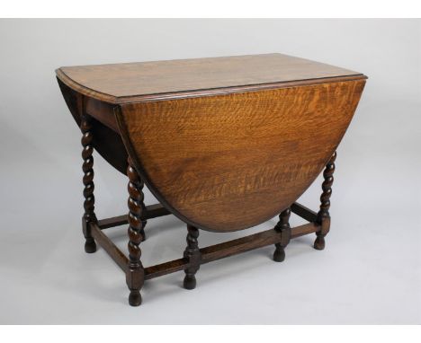 A Mid 20th Century Oak Drop Leaf Gate Leg Dining Table with Oval Top and Barley Twist Supports, 101cms Wide 