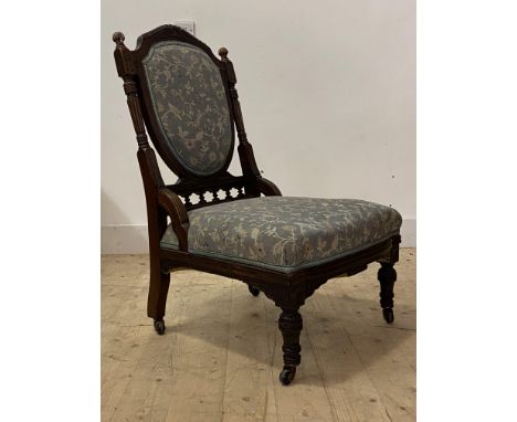 A late Victorian mahogany drawing room chair, the well carved and reeded frame enclosing upholstered seat and back, raised on