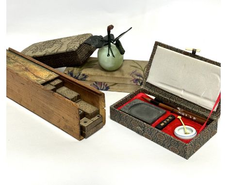 A celadon jadeite carved peach with spinach jade leaves, (5cm x 5cm), a Chinese style calligraphy set, two covered boxes and 