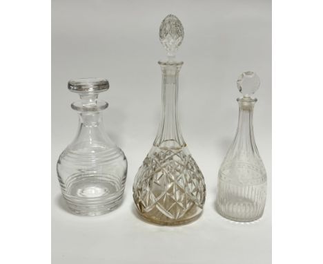 A crystal slice cut sherry decanter with faceted stopper (34cm), a modern crystal ring turned baluster decanter (23cm), and a