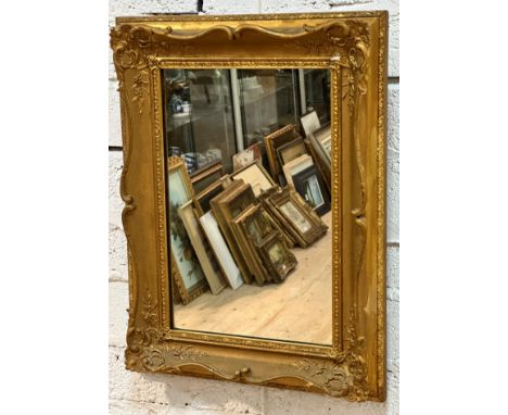 An Edwardian gilt composition rectangular rococo style wall mirror with later mirrored plate, (59cm x 45cm)
