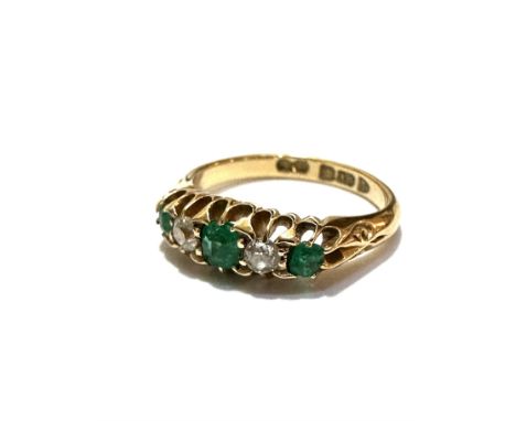 An 18ct gold three stone emerald and two stone diamond ring mounted in claw setting, the centre stone is approximately .15ct,