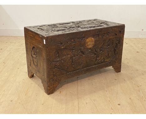 A mid 20th century Chinese carved camphor wood blanket box, the hinged lid revealing plain interior, raised on bracket suppor