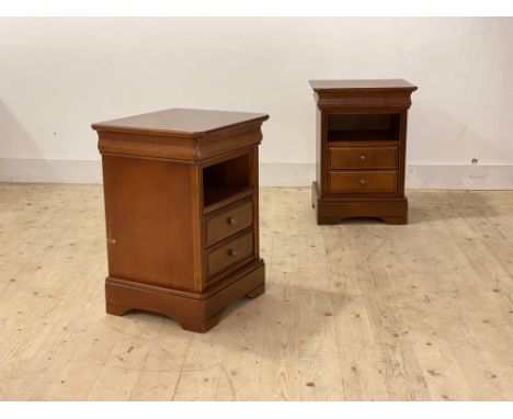 A pair of cherry bedside chests, each with moulded top over open shelf and two drawers, raised on bracket supports H65cm, W47