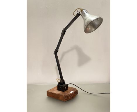 A vintage mid century articulated angle adjustable machinists lamp, with silvered conical shade, on a later naturalistic bur 