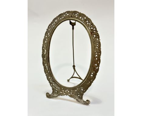 A white metal oval photograph frame raised on scroll end supports with easel stand, (internal measurements: 14cm x 9.5cm, 20c