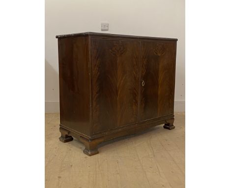 Whytock and Reid, a figured mahogany two door side cabinet, circa 1920s, with moulded edge over two doors enclosing a shelf t