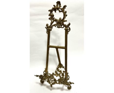 An Edwardian style cast brass picture easel of C scroll and S scroll design and tripod stand, (56cm, base 24cm)