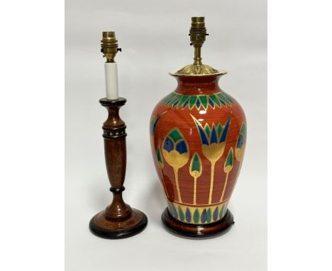 A modern Egyptian inspired terracotta glazed baluster vase table lamp, on hardwood stand, with stylised lotus flower and palm