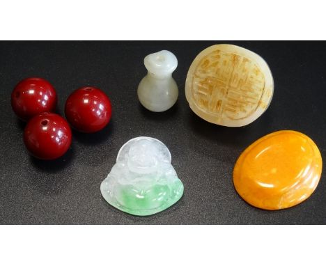 SMALL SELECTION OF JADE AND AMBER comprising three cherry amber beads, a jade seal, a small carved jade Buddha pendant, a sma