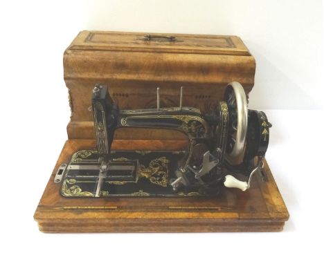 VINTAGE GERMAN METAL SEWING MACHINEcontained in a walnut and inlaid case 