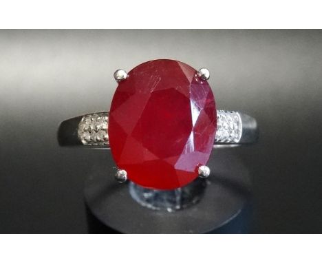 RUBY AND DIAMOND RINGthe central oval cut ruby approximately 3.5cts flanked by six small diamonds to each shoulder, on nine c