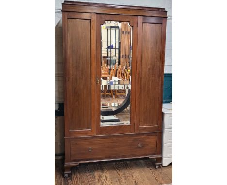 A 20th century mahogany mirrored-door wardrobe, with central mirror and two side doors, interior with a hanging rail and hook