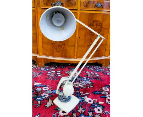 A cream coloured angle-poise lamp.&nbsp;Dent on shade