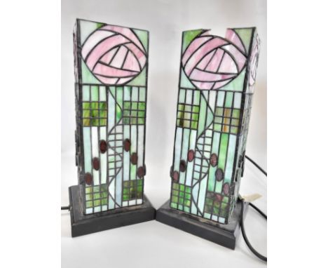 A pair of Tiffany style lamps. 32cm x 14cm. One lamp has a small piece missing from the top of the shade. Both lights work.