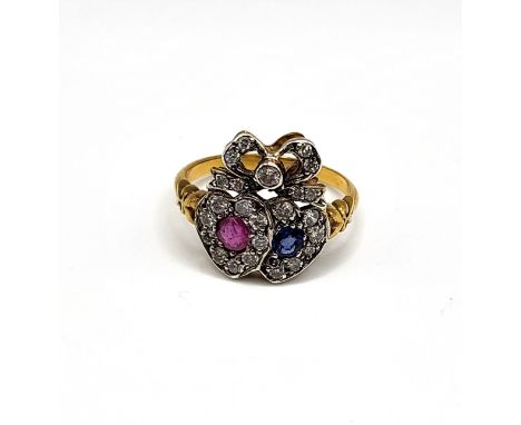 A diamond, ruby, and sapphire sweetheart ring, the ribbon-twist mount inset with round-cut diamonds, the hearts centred with 