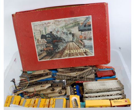 A large plastic container containing a quantity of Marklin 3-rail track, signals, bridges, buffer stops, switches, ramps, lig